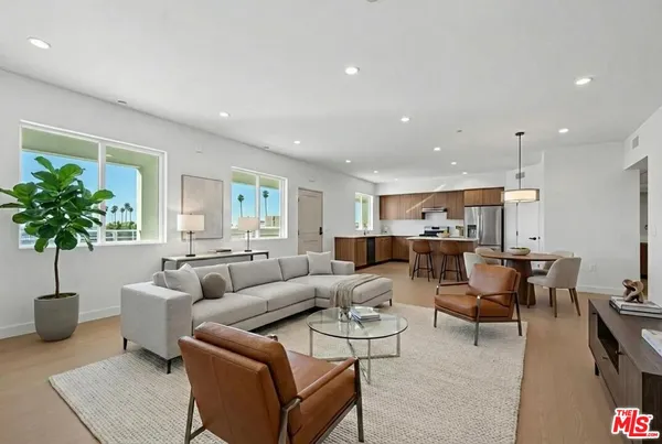 a living room with furniture a potted plant and a table