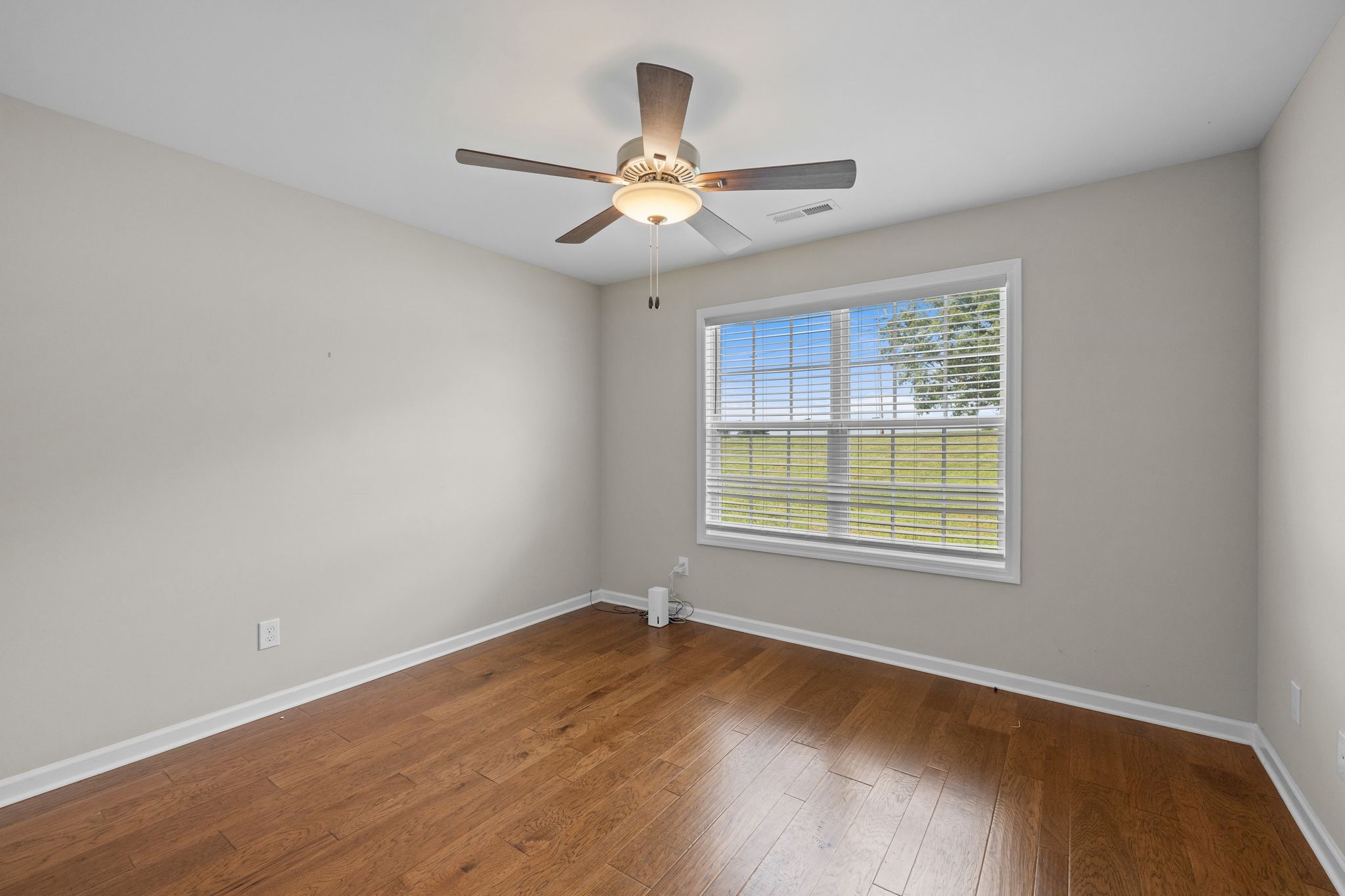 3232 Owl Hollow Road Belvidere, TN 37306 - Photo 20 of 43 an empty room with wooden floor chandelier fan and windows