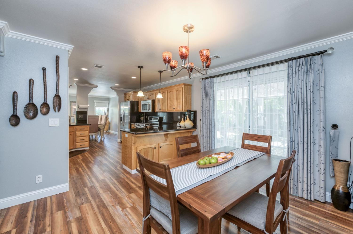 25106 Ave 18 Madera, CA 93638 - Photo 13 of 66 a view of a dining room with furniture a chandelier and wooden floor