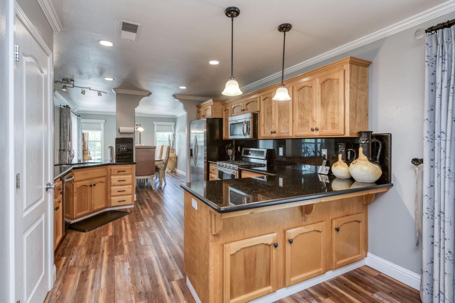 25106 Ave 18 Madera, CA 93638 - Photo 15 of 66 a kitchen with stainless steel appliances granite countertop a sink a stove and a wooden floors