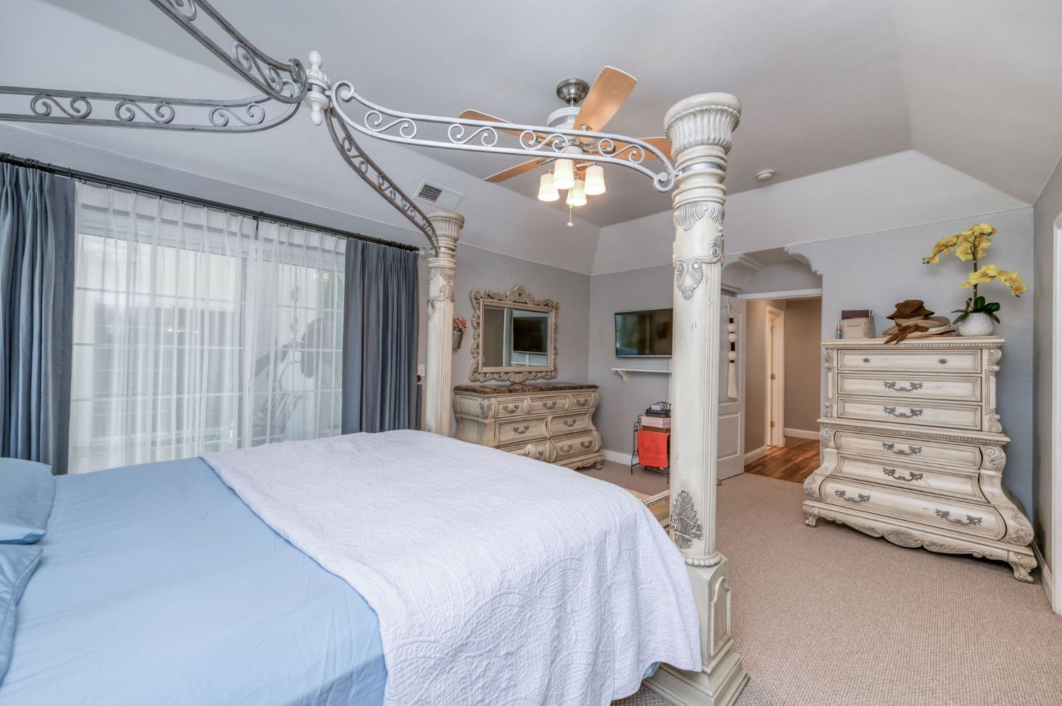 25106 Ave 18 Madera, CA 93638 - Photo 24 of 66 a bedroom with a bed and a chandelier