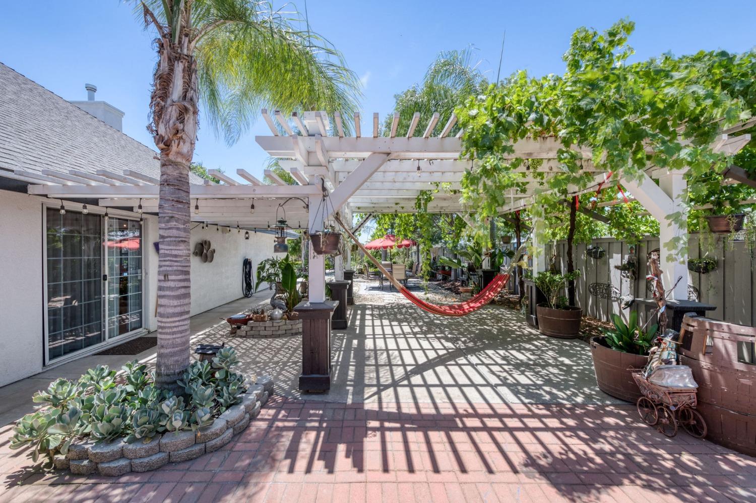 25106 Ave 18 Madera, CA 93638 - Photo 28 of 66 a view of a patio with table and chairs potted plants and large tree