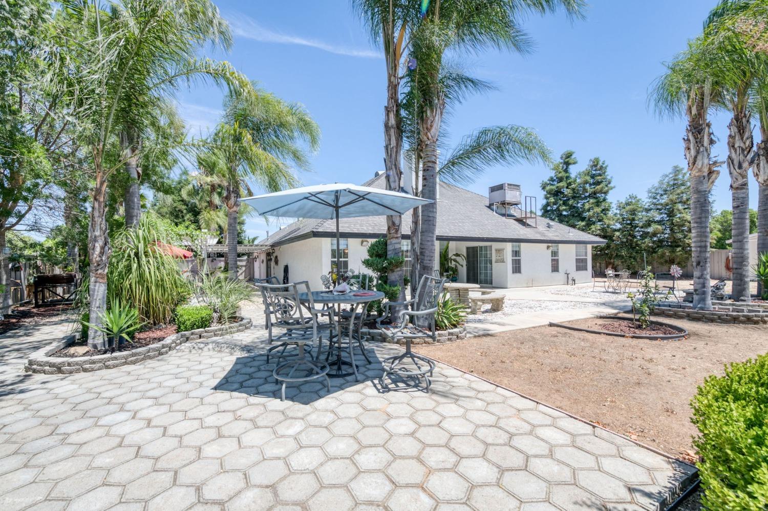 25106 Ave 18 Madera, CA 93638 - Photo 36 of 66 a view of a patio with a table and chairs under an umbrella