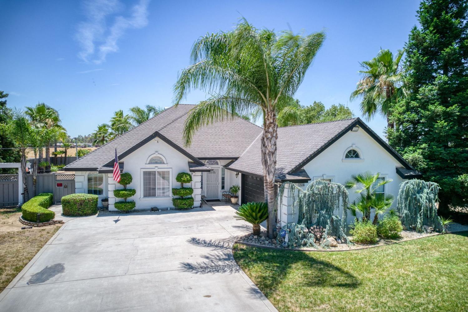 25106 Ave 18 Madera, CA 93638 - Photo 65 of 66 a view of a white house with a big yard plants and palm trees