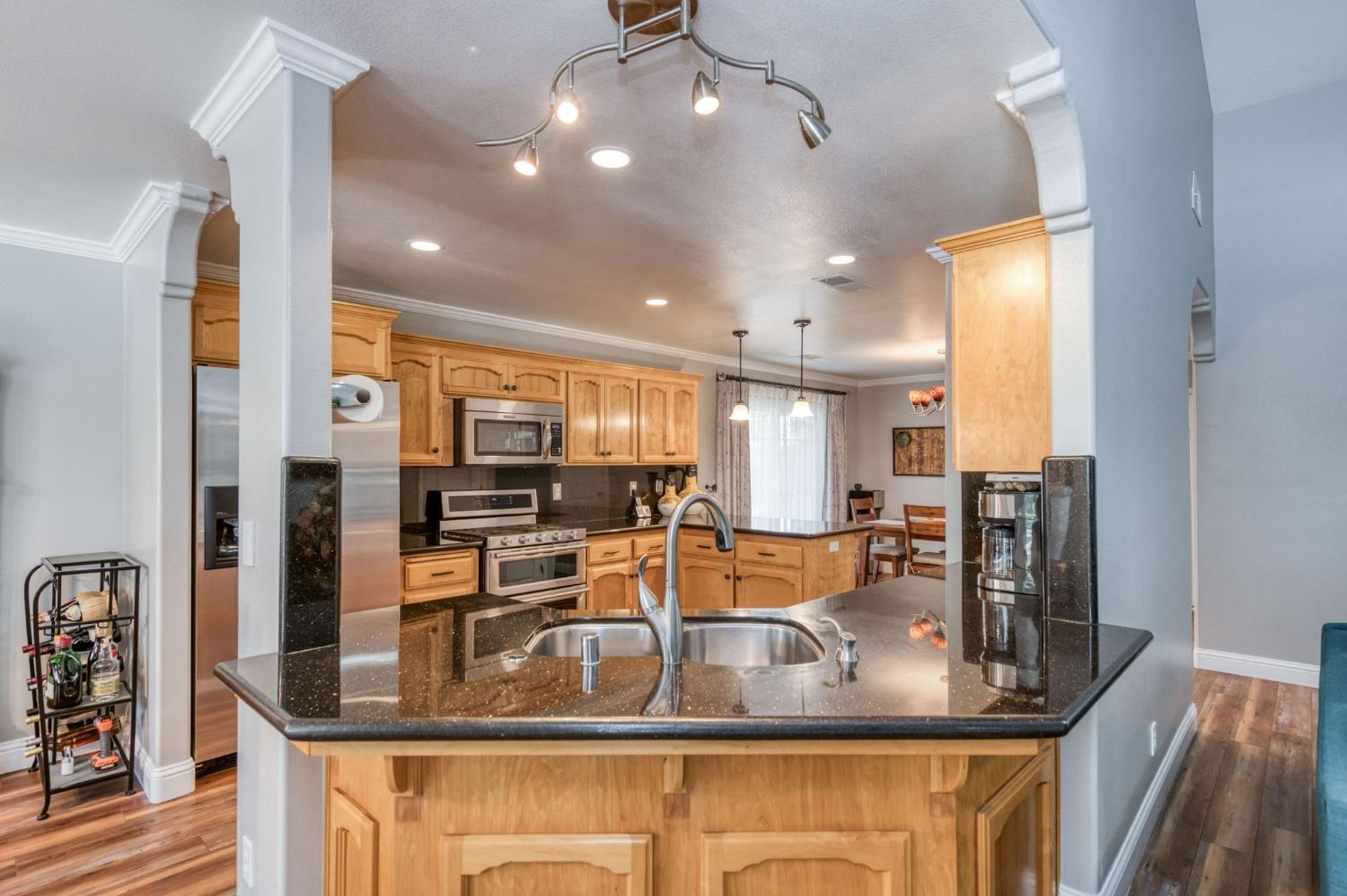 25106 Ave 18 Madera, CA 93638 - Photo 8 of 66 a kitchen with stainless steel appliances granite countertop a sink refrigerator and cabinets