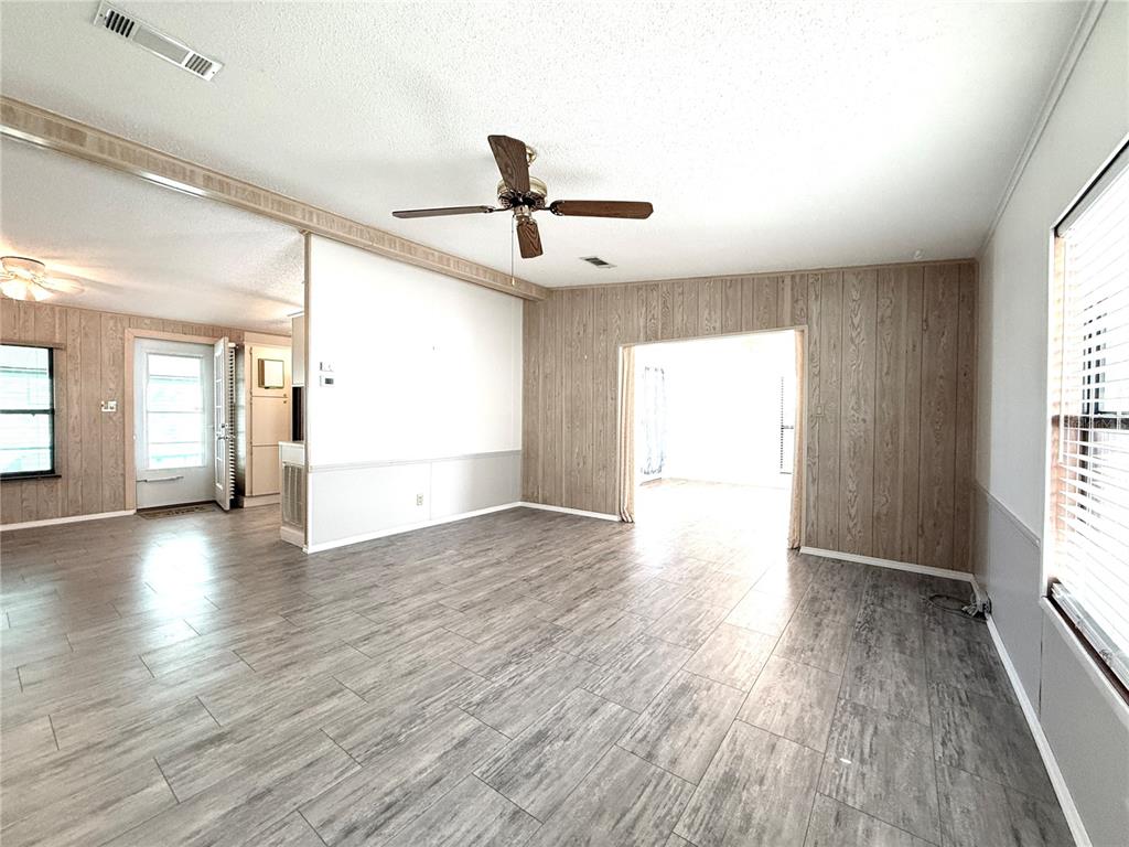 108 North St George Circle Apollo Beach, FL 33572 - Photo 3 of 34 wooden floor in an empty room with a window