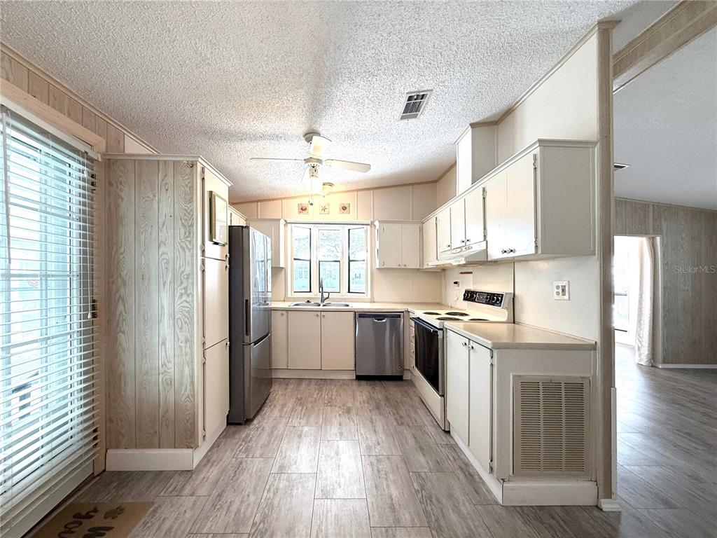 108 North St George Circle Apollo Beach, FL 33572 - Photo 6 of 34 a large kitchen with a wooden floor and cabinets