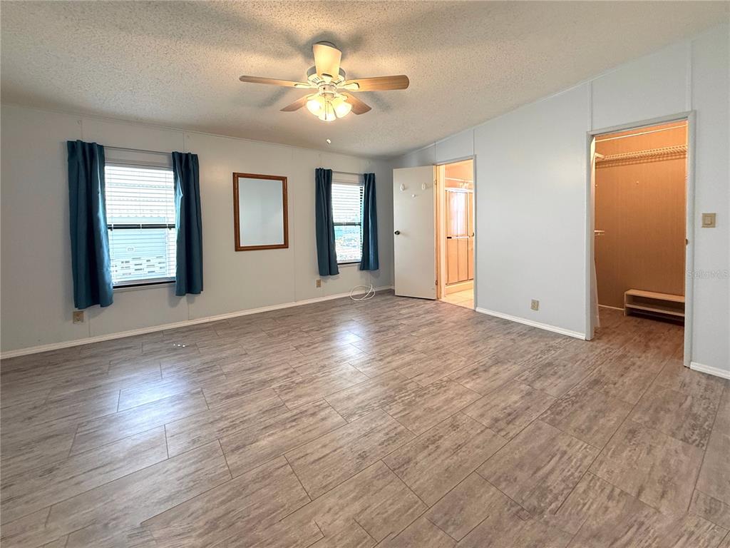 108 North St George Circle Apollo Beach, FL 33572 - Photo 8 of 34 an empty room with wooden floor and windows