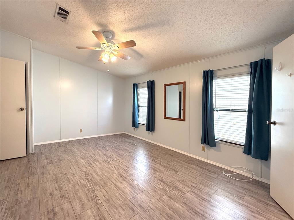 108 North St George Circle Apollo Beach, FL 33572 - Photo 10 of 34 a view of an empty room with window and wooden floor