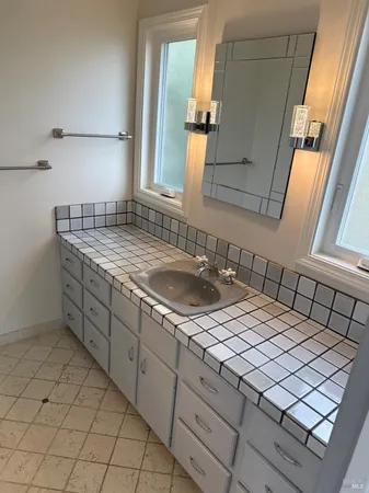 a bathroom with a granite countertop sink and a mirror