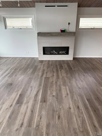 a view of a hallway with wooden floor and closet area