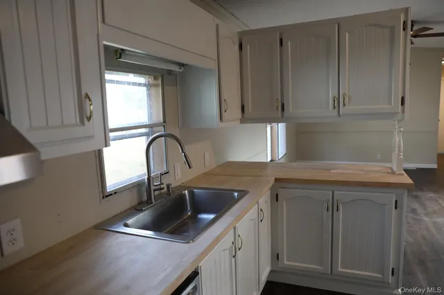 a kitchen with a sink cabinets and a window