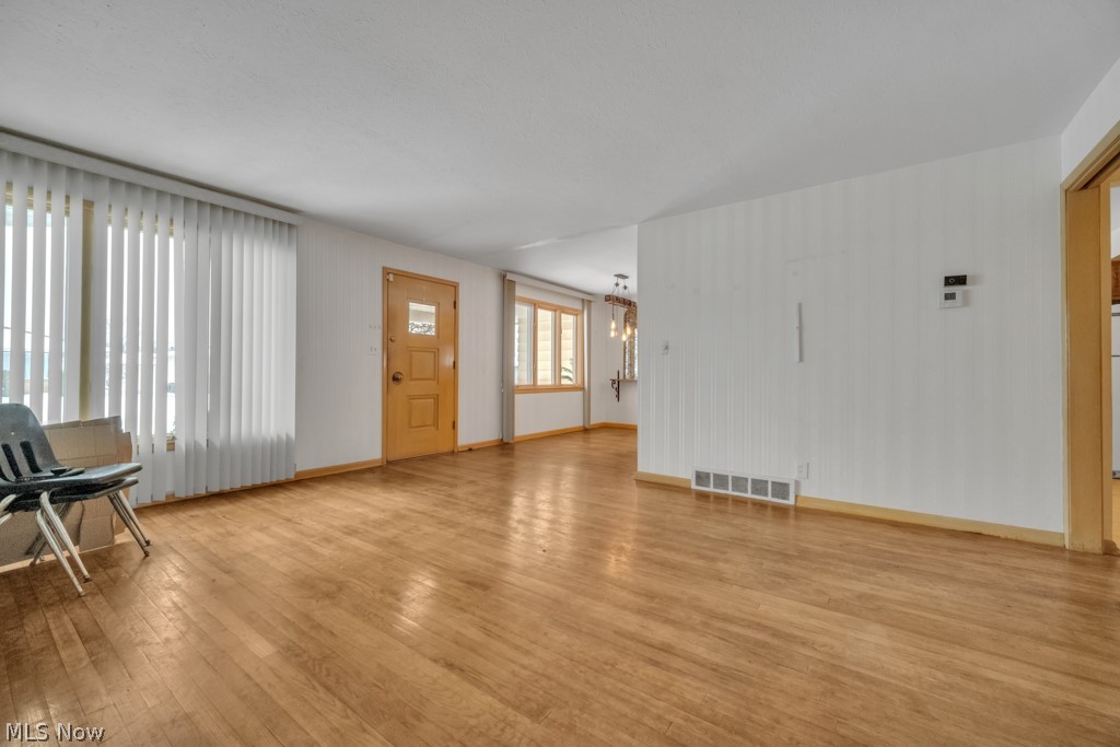 6846 Revere Road Cleveland, OH 44130 - Photo 15 of 30 Unfurnished living room with light wood finished floors and hanging lights