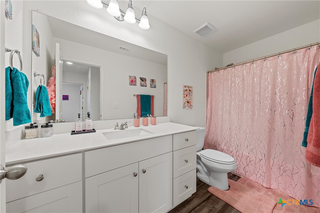 121 Sudden Impact Drive Jarrell, TX 76537 - Photo 20 of 38 a bathroom with a double vanity sink mirror and toilet