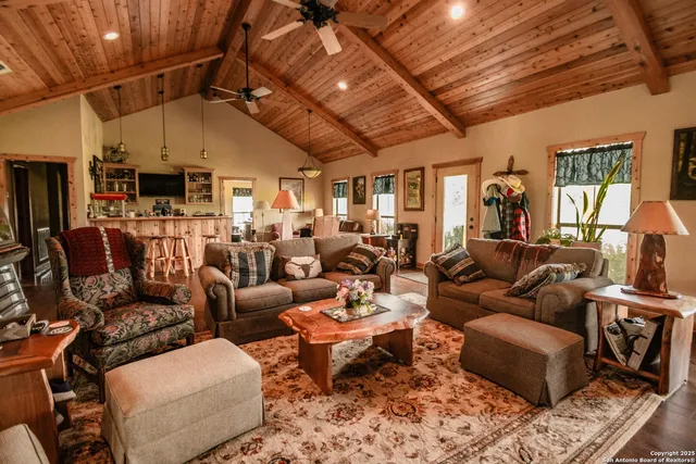 a living room with lots of wooden furniture and a flat screen tv