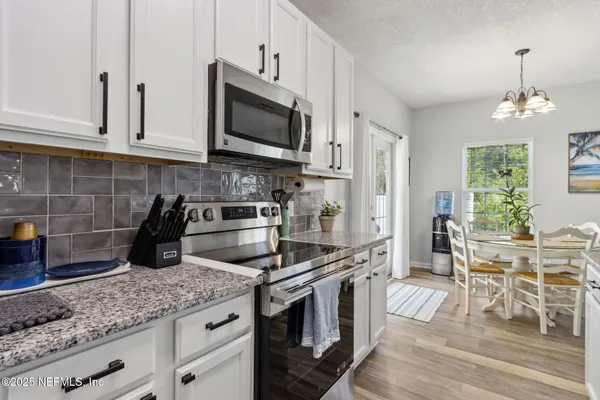 a kitchen with counter top space cabinets and appliances
