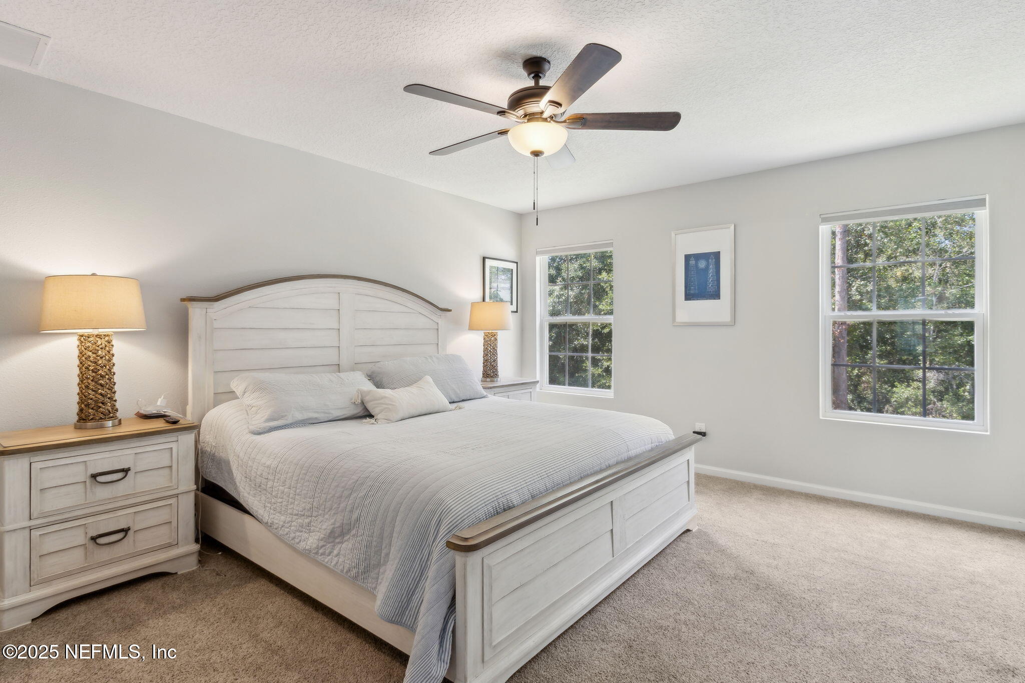 95152 Cypress Trail Fernandina Beach, FL 32034 - Photo 19 of 29 a bedroom with a large bed and a chandelier