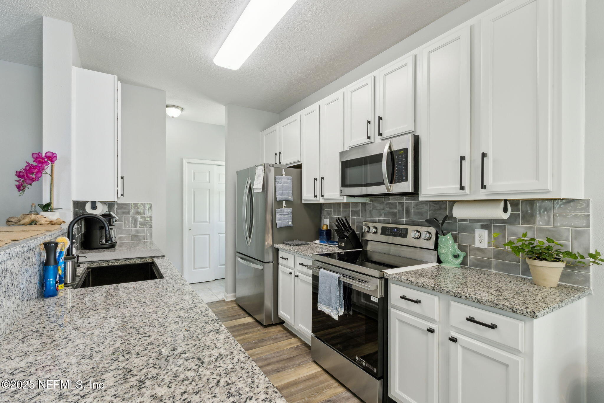 95152 Cypress Trail Fernandina Beach, FL 32034 - Photo 8 of 29 a kitchen with granite countertop a sink stove and refrigerator