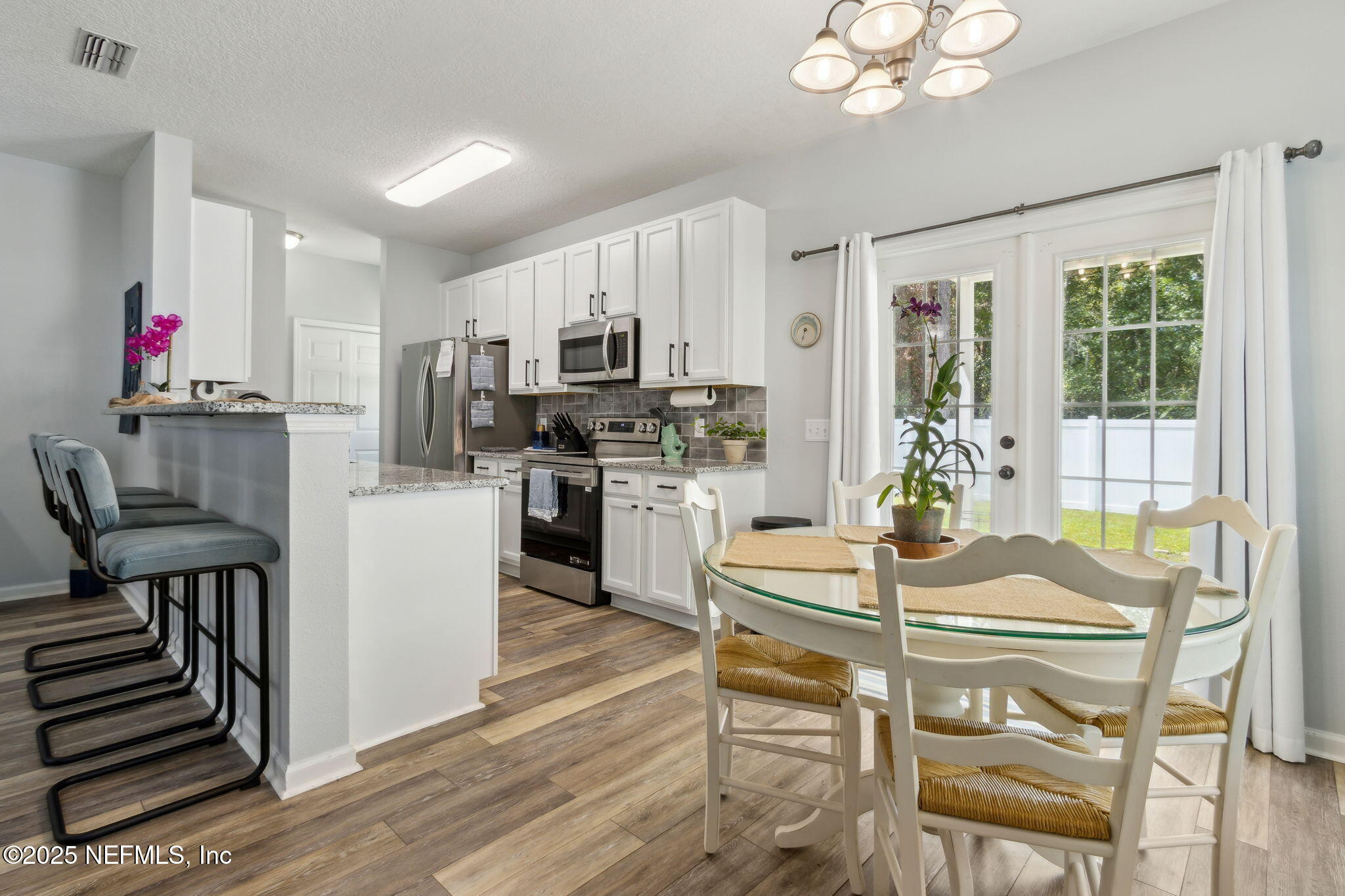95152 Cypress Trail Fernandina Beach, FL 32034 - Photo 10 of 29 a kitchen with sink refrigerator dining table and chairs