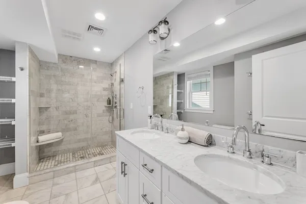 a spacious bathroom with a double vanity sink mirror and shower
