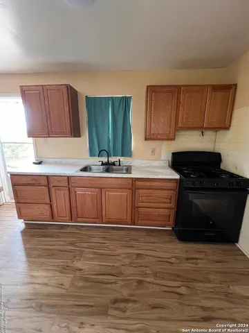 a kitchen with stainless steel appliances granite countertop a sink a stove and a refrigerator