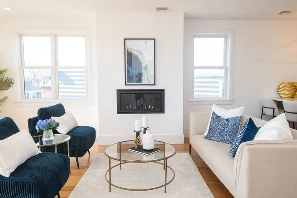 a living room with furniture a flat screen tv and a large window