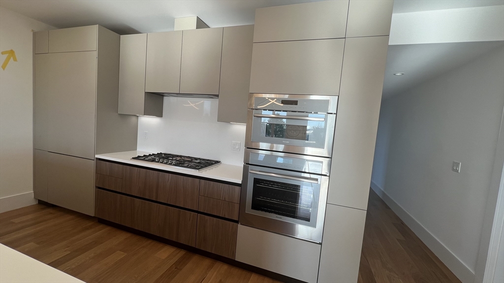 726 East 8th Street, Unit 3 Boston, MA 02127 - Photo 9 of 11 a kitchen with granite countertop white cabinets and stainless steel appliances