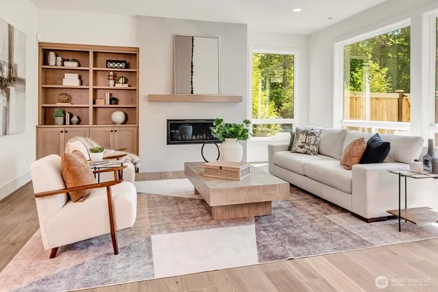 a living room with fireplace furniture and a large window