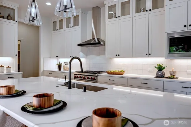a kitchen with stainless steel appliances a sink a stove and cabinets