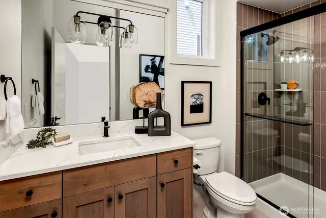 a bathroom with a sink a toilet and shower