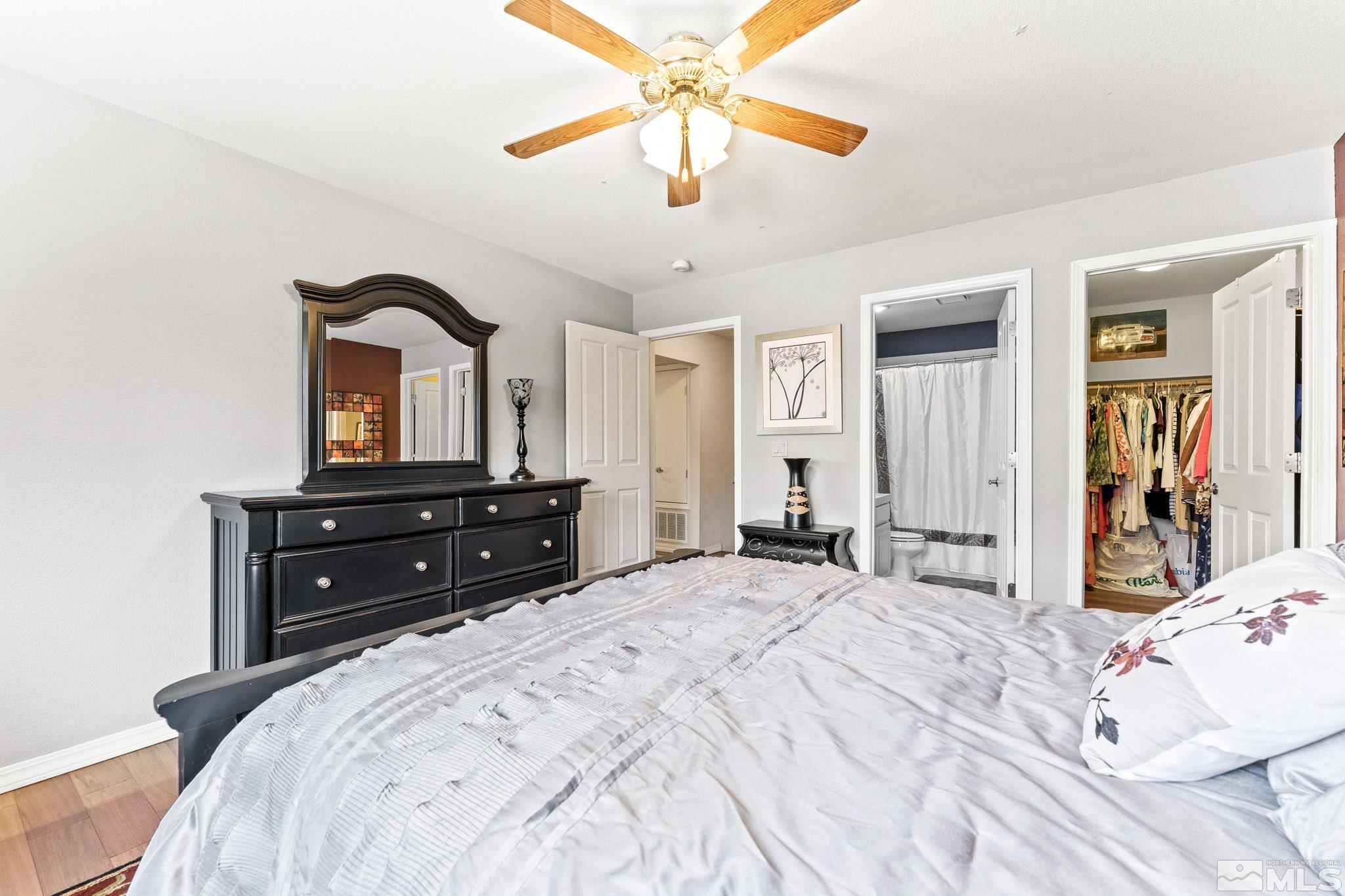 6444 Brookview Circle Reno, NV 89519 - Photo 21 of 32 a bedroom with a bed a chandelier and a mirror