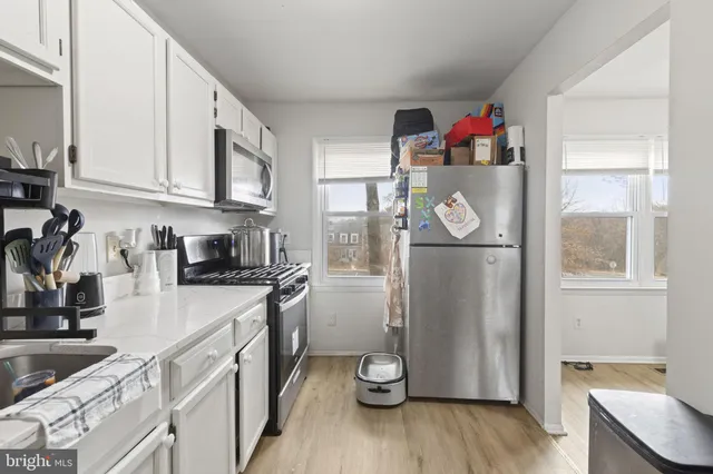 a kitchen with granite countertop stainless steel appliances a refrigerator a sink and cabinets