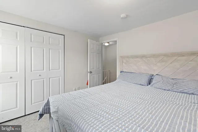 a bedroom with a white bed and a shower