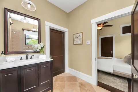 a en suite bathroom with a double vanity sink a mirror and a bathtub