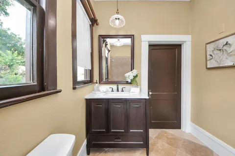 a bathroom with a toilet a sink and a window