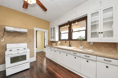 a kitchen with granite countertop white cabinets and white appliances