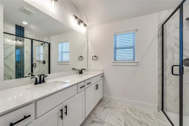 a bathroom with a double vanity sink and mirror with shower