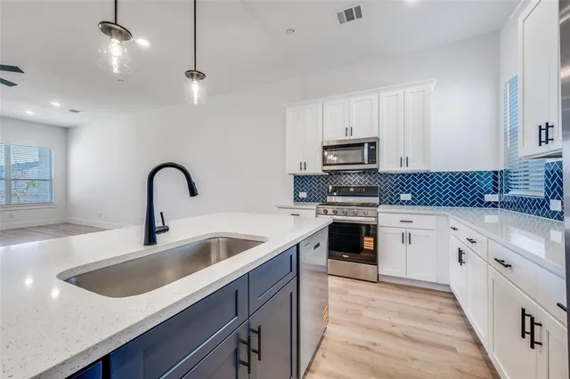 a kitchen with granite countertop a sink stove and cabinets