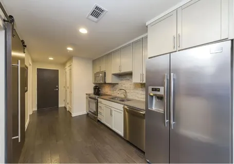 a kitchen with stainless steel appliances granite countertop a refrigerator and a sink