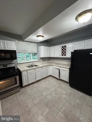 a kitchen with a sink a stove and cabinets