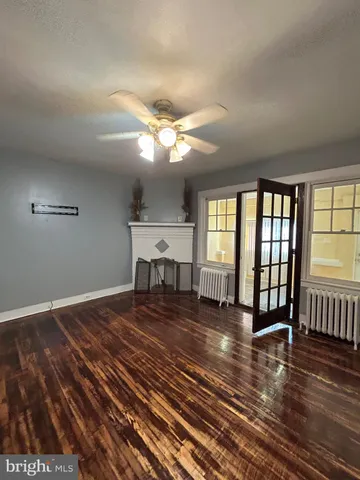 a view of a livingroom with wooden floor and a ceiling fan
