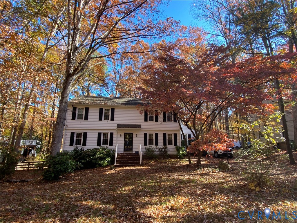 a front view of a residential houses with yard and trees