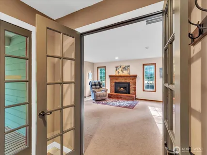a view of an empty room with fireplace and a window