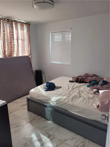 a bedroom with a bed and a refrigerator