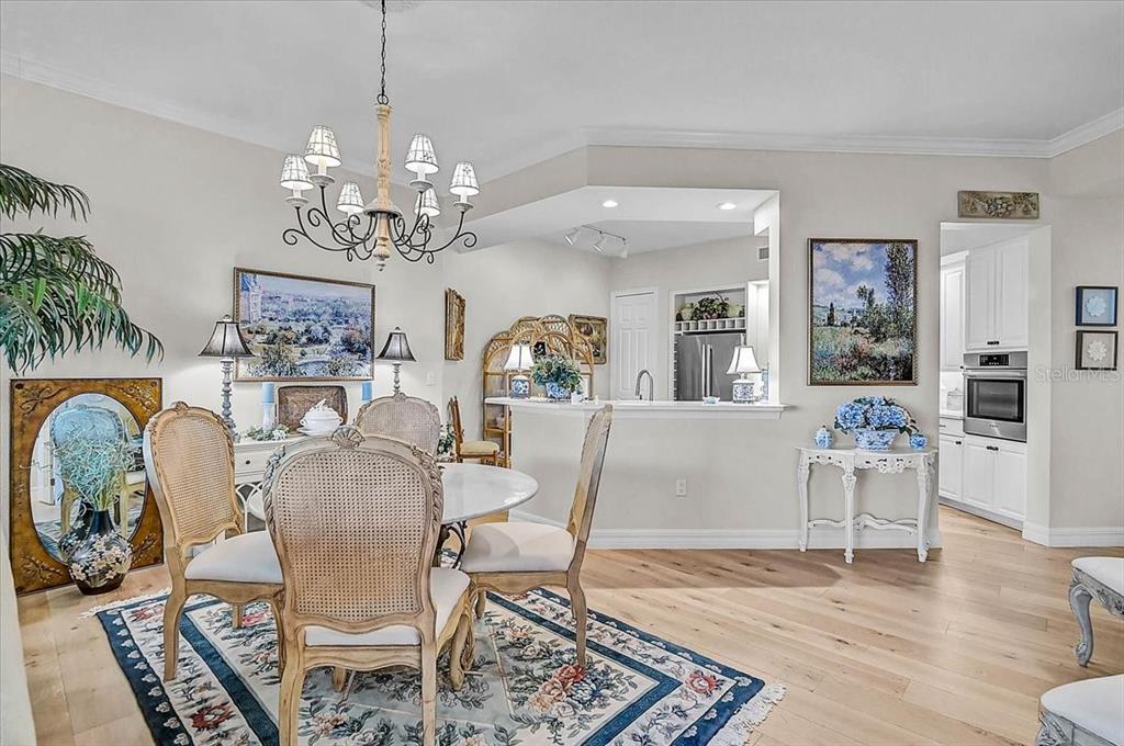 409 North Point Road, Unit 902 Osprey, FL 34229 - Photo 12 of 59 a dining room with furniture a chandelier and wooden floor