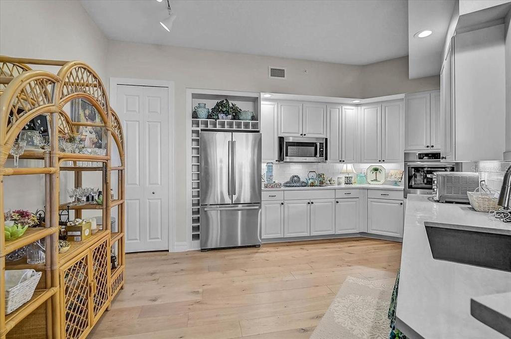 409 North Point Road, Unit 902 Osprey, FL 34229 - Photo 14 of 59 a kitchen with white cabinets and stainless steel appliances