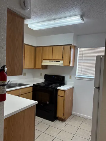 a kitchen with a stove a refrigerator and cabinets