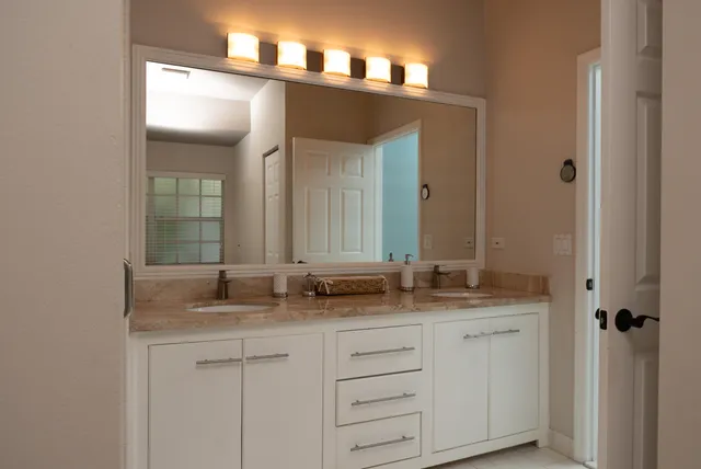 a bathroom with a granite countertop sink and a mirror