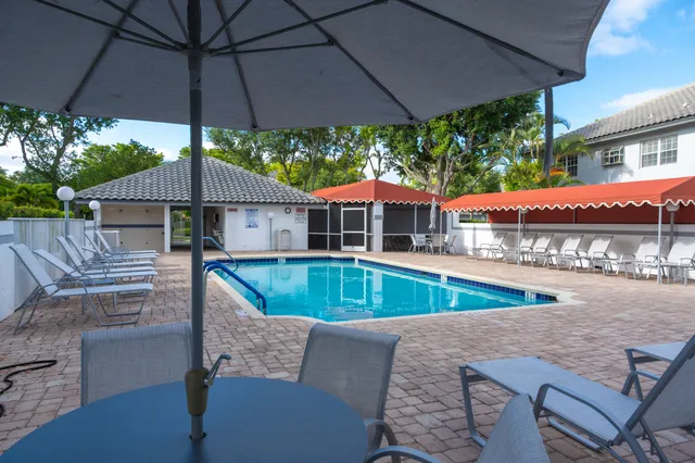 a view of a patio with a table and chairs under an umbrella