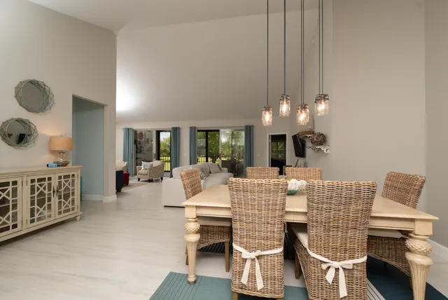 a view of an dining room and livingroom with furniture wooden floor windows and a chandelier